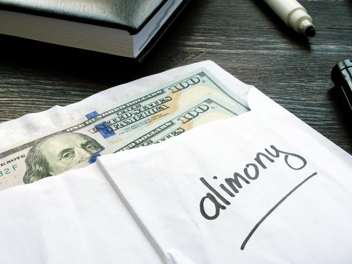 An envelope marked “Alimony” with a wad of cash inside